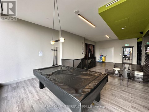 A modern bedroom with a large bed and a green accent wall.