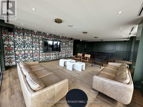 A living room with a floral wallpaper and a flat screen TV.