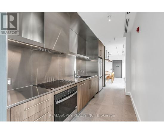 A modern kitchen with stainless steel appliances and wooden cabinets.