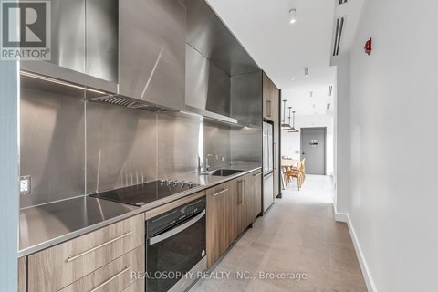 A modern kitchen with stainless steel appliances and wooden cabinets.