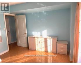 A room with a white door and a white dresser with a window behind it.