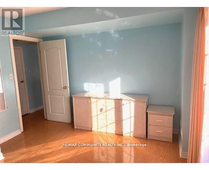 A room with a white door and a white dresser with a window behind it.