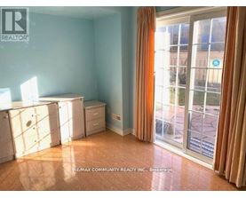 A room with a sliding glass door leading to a balcony.