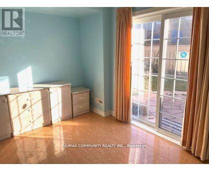 A room with a sliding glass door leading to a balcony.
