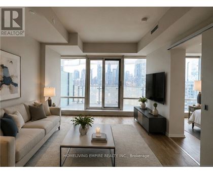 A living room with a couch, a coffee table, and a flat-screen TV.