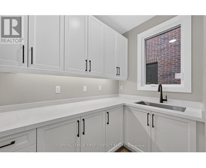 A kitchen with white cabinets and a brick wall in the background.