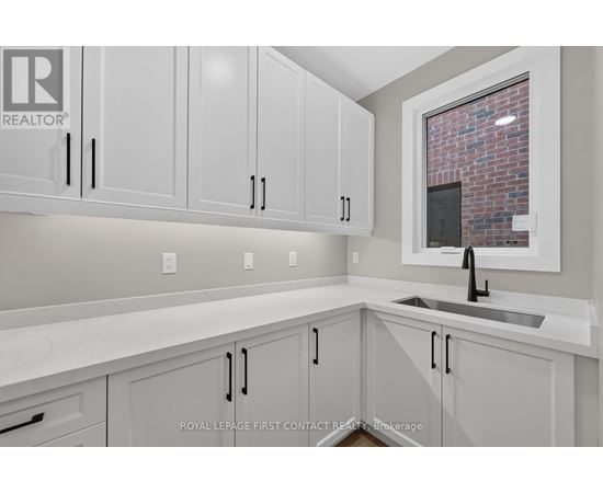 A kitchen with white cabinets and a brick wall in the background.
