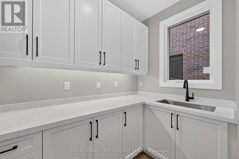 A kitchen with white cabinets and a brick wall in the background.