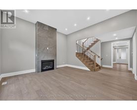 A spacious room with a fireplace and a staircase.