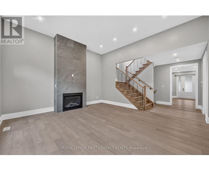 A spacious room with a fireplace and a staircase.