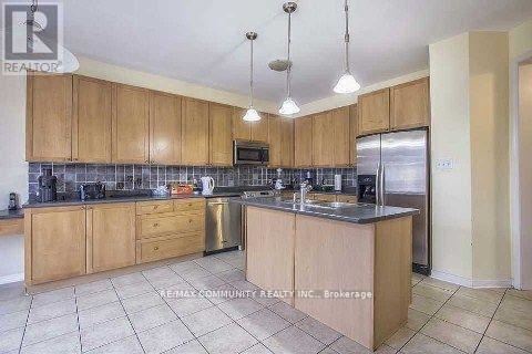 A kitchen with wooden cabinets and a tile floor.