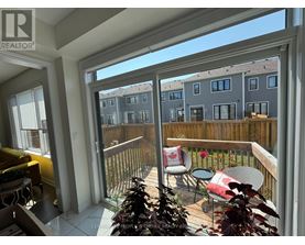 A balcony with a table and chairs overlooks a building.