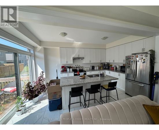 A kitchen with white cabinets and a granite countertop.