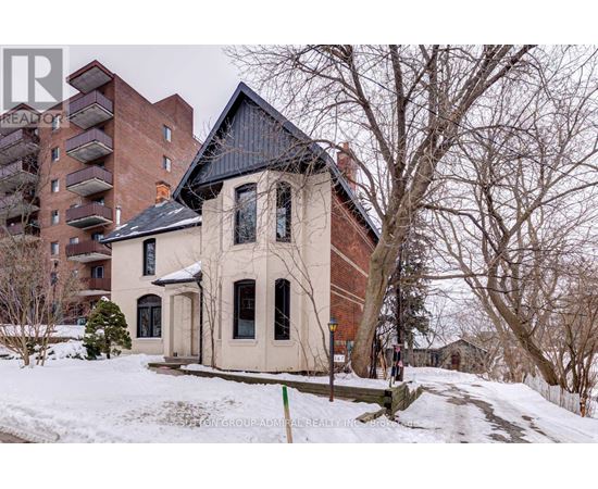 A house with a black roof is surrounded by snow.