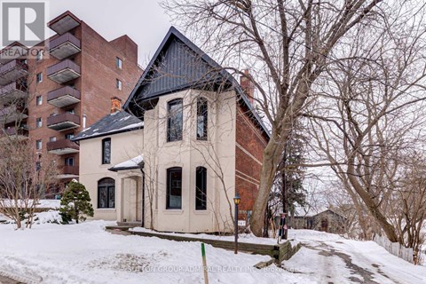 A house with a black roof is surrounded by snow.