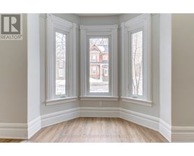 A room with a view of a red brick building through the windows.