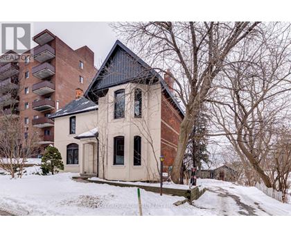 A house with a black roof is surrounded by snow.