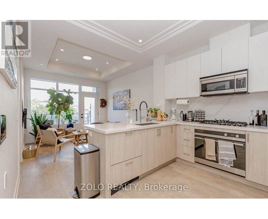 A modern kitchen with white cabinets and stainless steel appliances.