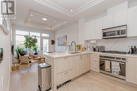 A modern kitchen with white cabinets and stainless steel appliances.