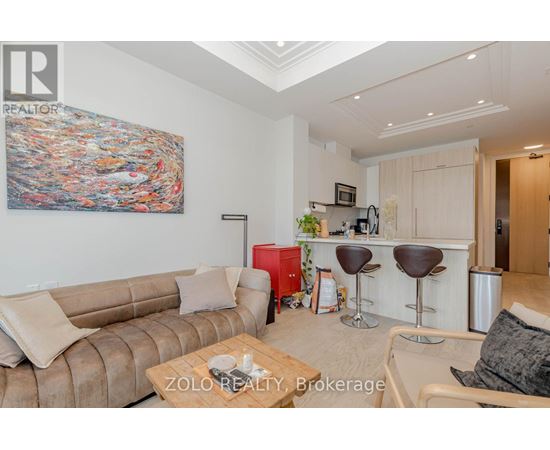 A living room with a couch, a coffee table, and a painting on the wall.