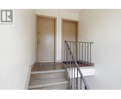 A staircase with a metal railing and wooden steps leading to a door.