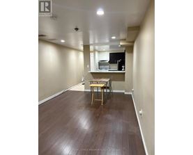 A room with a wooden floor and a table with chairs.