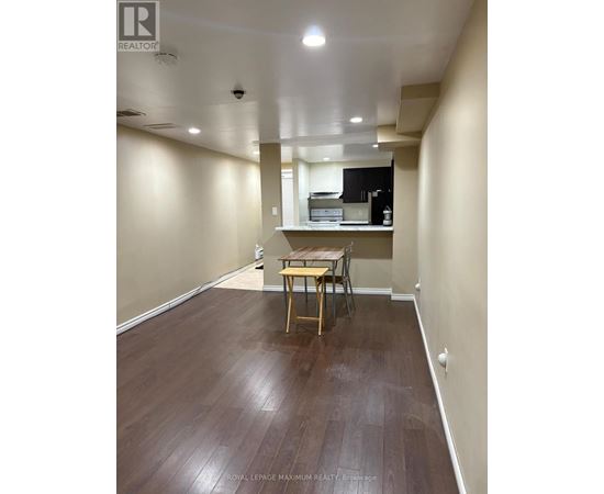 A room with a wooden floor and a table with chairs.