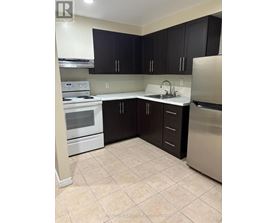 A kitchen with black cabinets and stainless steel appliances.