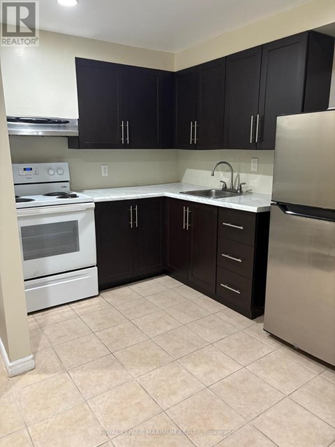 A kitchen with black cabinets and stainless steel appliances.
