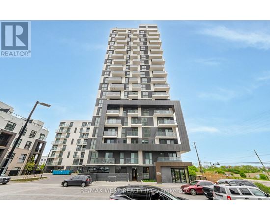 A tall residential building with a parking lot in front.