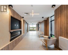 A modern living room with a flat screen TV and a wood panelled wall.