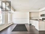 A black mat is on the floor of a white room.