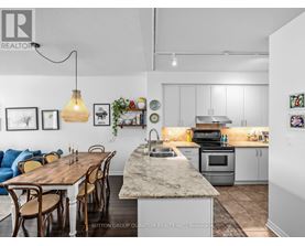 A kitchen with a table and chairs in the foreground and a fridge in the background.