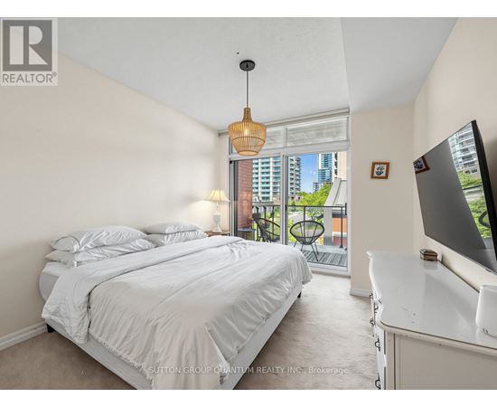 A bedroom with a large bed and a television.