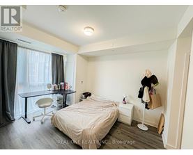 A bedroom with a bed, desk, and chair.