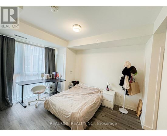 A bedroom with a bed, desk, and chair.