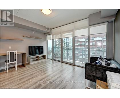 A living room with a couch, television, and sliding glass doors.