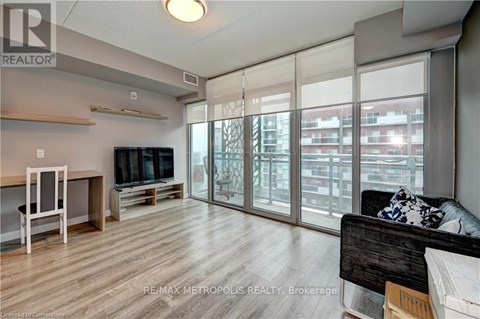 A living room with a couch, television, and sliding glass doors.