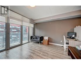 A room with a desk and a couch with a box on the floor.