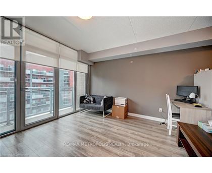 A room with a desk and a couch with a box on the floor.