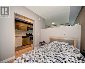 A bedroom with a patterned bedspread and a small bedside table.