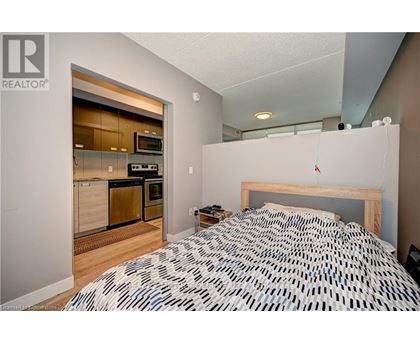 A bedroom with a patterned bedspread and a small bedside table.
