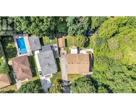 A bird's eye view of a residential area with houses and a swimming pool.