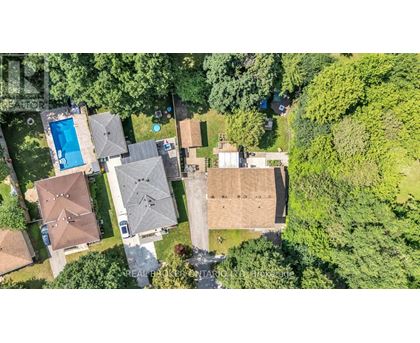 A bird's eye view of a residential area with houses and a swimming pool.