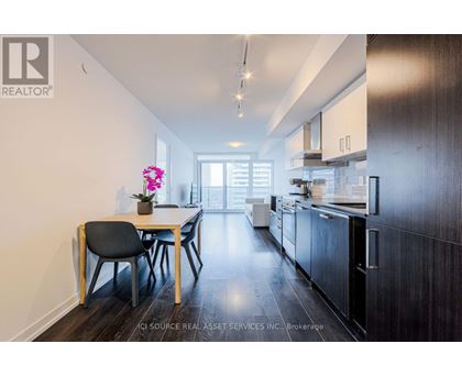 A modern kitchen with dark wood cabinets and a dining table with four chairs.