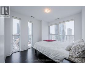 A bedroom with a large bed and a view of the city.