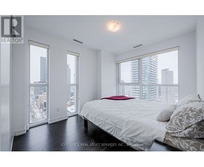 A bedroom with a large bed and a view of the city.
