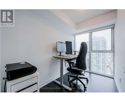 A room with a desk, chair, and printer.