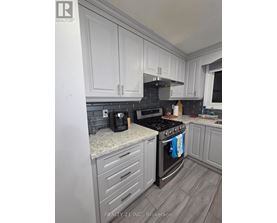 A kitchen with white cabinets and a black stove top.