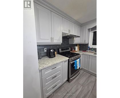 A kitchen with white cabinets and a black stove top.